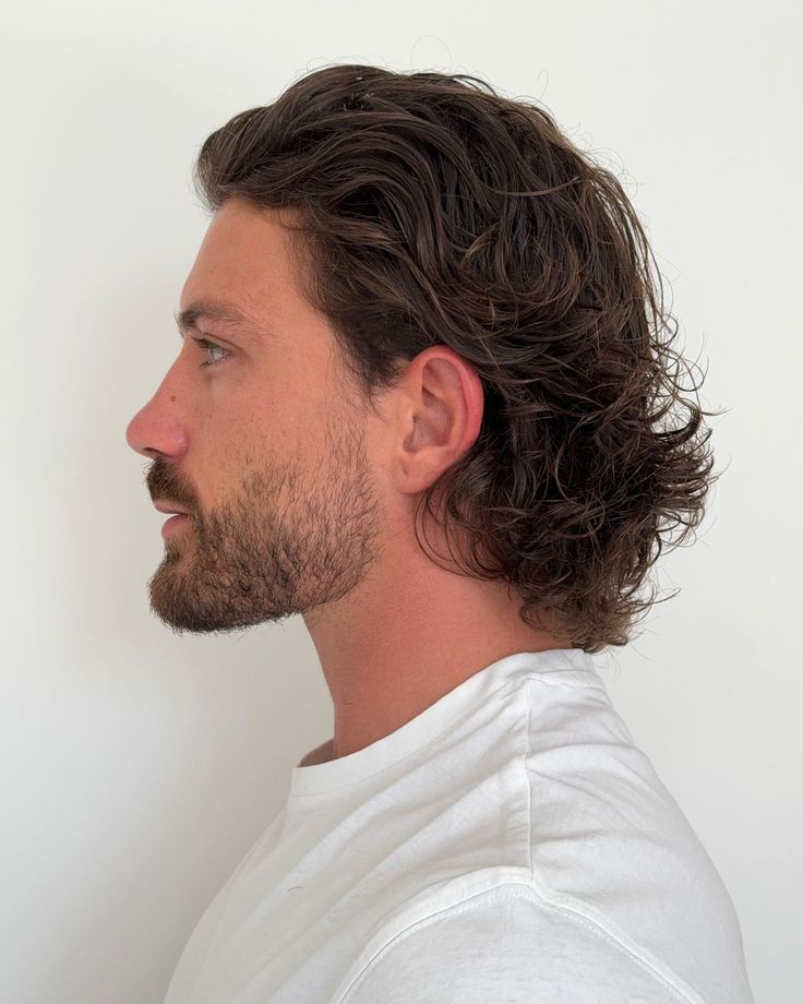 Long wavy modern mullet with stubble beard at Empire Barbershop Amsterdam