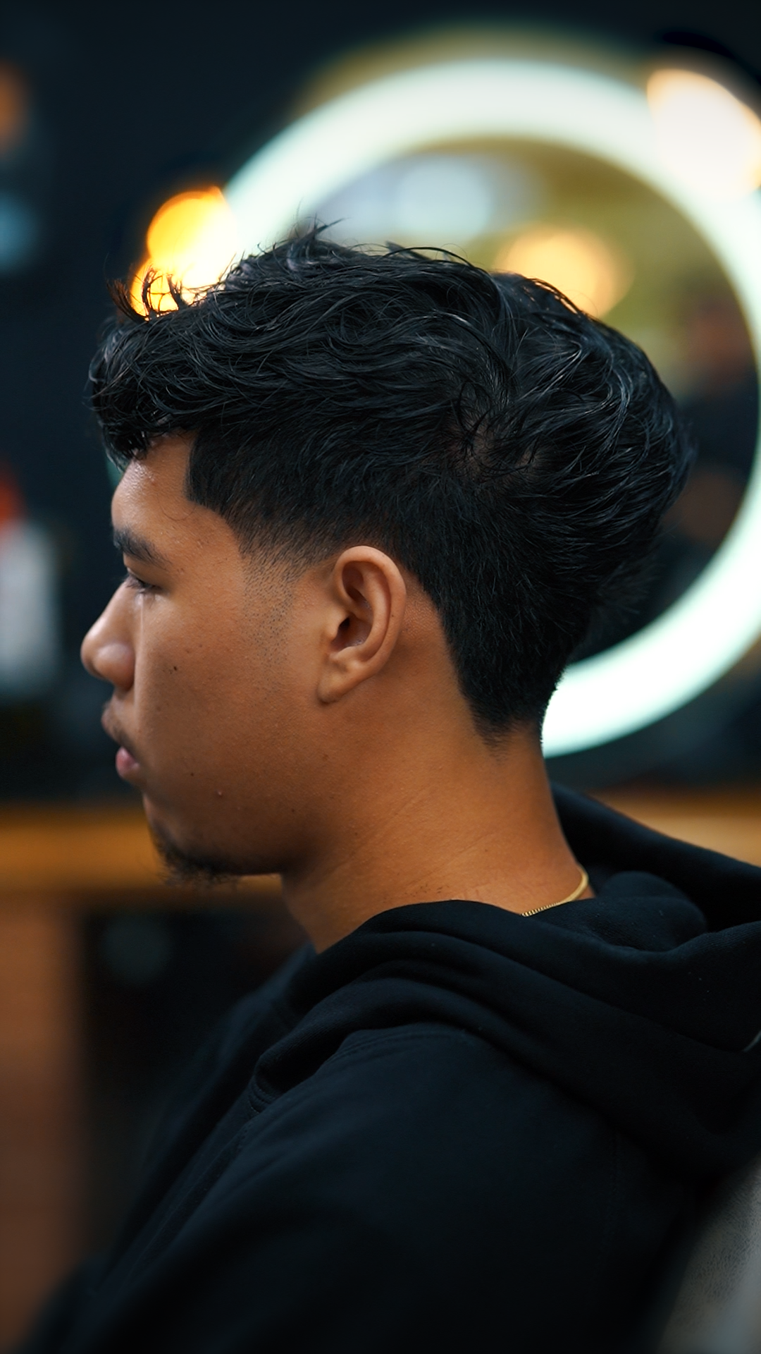 Layered low taper haircut on textured hair at Empire Barbershop Amsterdam